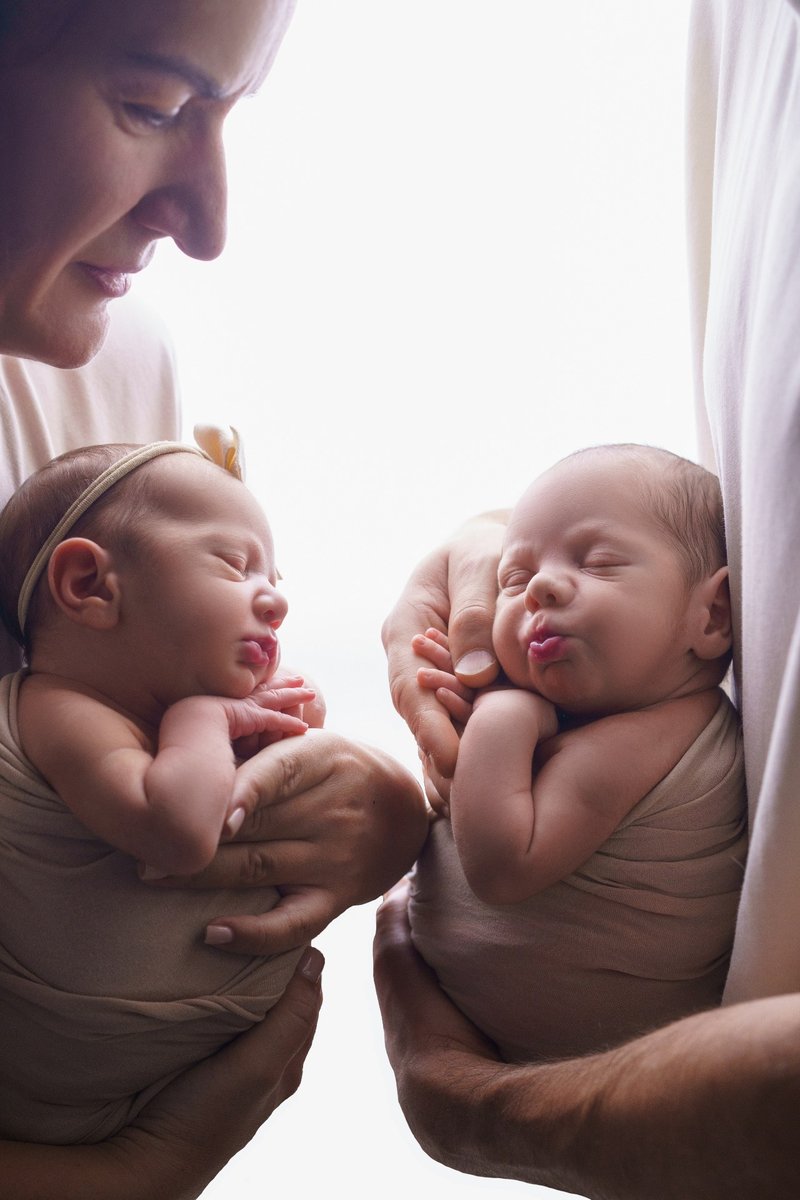 Новорождённые близнецы на руках родителей — фотосессия Рига